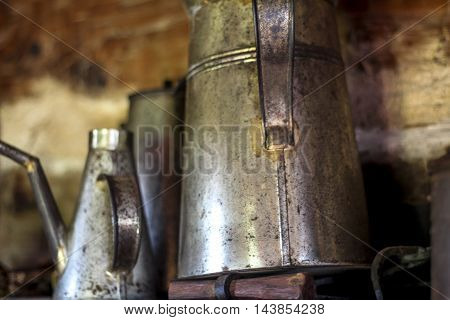 Antique pot and cups sit on shelf.