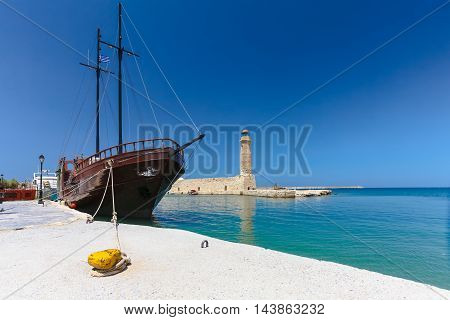 Rethymnon, Island Crete, Greece, - July 1, 2016: View of the harbor with lighthouse and the old sailing ship. Rethymnon is an old historic town on the northern coast of the island Crete.