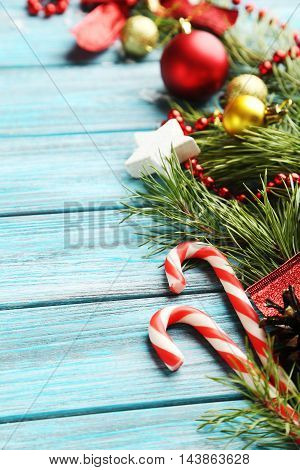 Christmax Tree Branch With Baubles, Candies On Blue Wooden Table