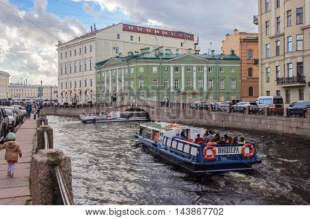ST. PETERSBURG, RUSSIA - AUGUST 14, 2016: Pleasure boat with tourists on the Moika River near the Griboyedov Canal