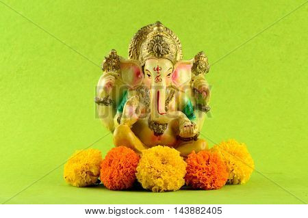 Hindu God Ganesha. Ganesha Idol on Green Background