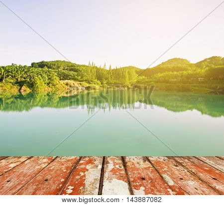 Wood floor top on river with green tree in nature