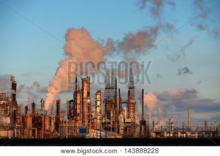 Oil refinery with smokestacks releasing emissions into the atmosphere