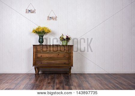 Dresser in home inrerrior decorated with flovers and plates