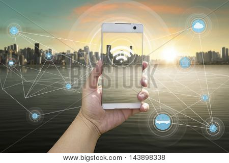 Hand holding white phone with city scape and wifi network connection concept .