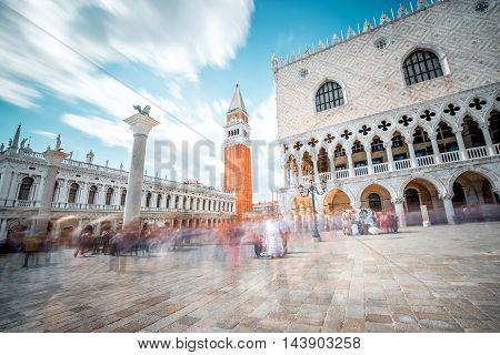 View on San Marco campanille and Doges palace in the center of Venice. Long exposure image technic with motion blurred people