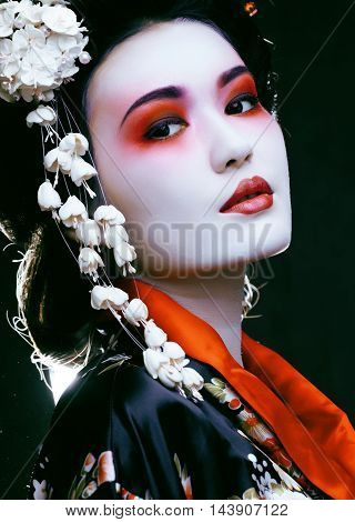 Young beautiful asian woman's portrait, geisha in kimono on black