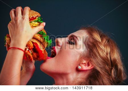 Girl with mouth wide open hamburger eating hamburger. Hamburger is tasty food.