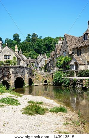 CASTLE COMBE, UNITED KINGDOM - JULY 20, 2016 - Stone bridge over the river Bybrook with cottages to the rear Castle Combe Wiltshire England UK Western Europe, July 20, 2016.