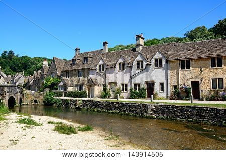 Stone cottages alongside the river Bybrook Castle Combe Wiltshire England UK Western Europe.