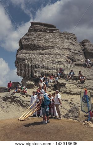 Bucegi Mountains Romania - August 6 2016: People come to contemplate meditate or rest at Sphinx the famous sacred megalith with human face likeness located at 2216 m altitude in Bucegi Mountains.