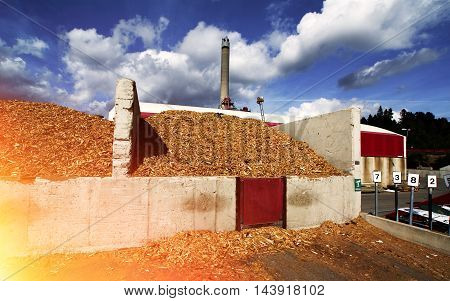 Bio Power Plant With Storage Of Wooden Fuel Against Blue Sky
