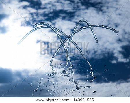 Fountain fresh water splash on hot summer sky background. Clear water or refreshment theme.