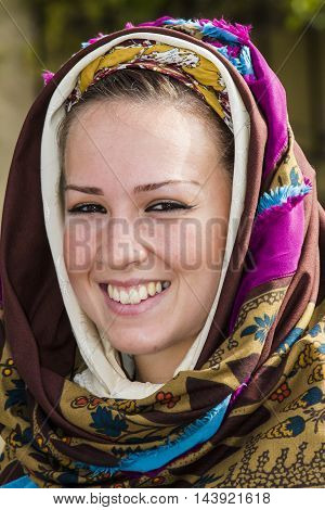 QUARTU S.E., ITALY - September 21, 2014: Parade of Sardinian costumes and floats for the grape festival in honor of the celebration of St. Helena. - Portrait of a beautiful smiling girl in traditional Sardinian costume