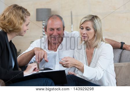 senior couple negociating with businesswoman for new investment