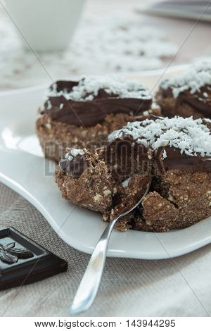 A photo of chocolate cakes on a white plate with a spoon