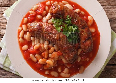Pork Sausages With Beans And Cooked Tomatoes On A Plate Closeup. Horizontal Top View