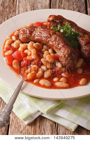 Grilled Sausage With Beans In Tomato Sauce On A Plate Close-up. Vertical