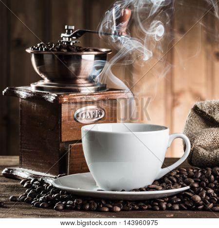 still life with coffee beans and old coffee mill on the wooden background