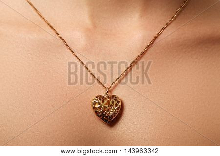 Golden Heart Pendant. Beauty And Jewelry Concept. Woman Wearing
