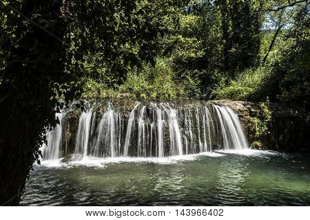 small waterfall and small lake in a forest closeup