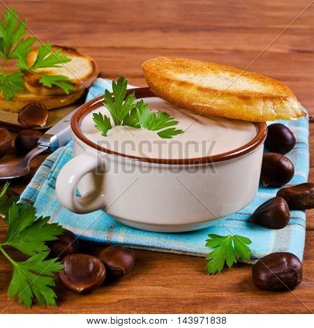 Cream soup of pureed chestnuts on a wooden background. Selective focus.