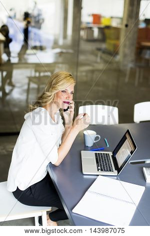Manageress With Mobile Phone In Office