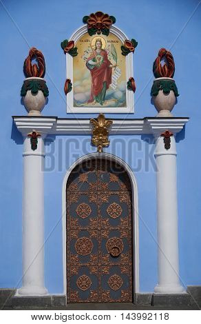 The metal door to the Orthodox Church with the icon in the style of Ukrainian Baroque. Bas-reliefs in the form of columns vases flowers painted in different colors. The cathedral church in honor of the Archangel Michael Kiev