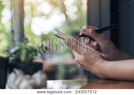 Closeup Image Of A Businesswoman's Hand Working And Holding A White Blank Notebook With Screwed Up P