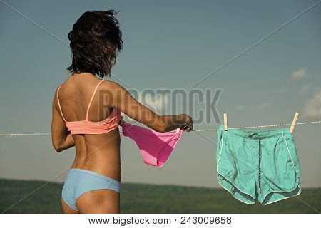 Sexy Woman. Girl Or Housewife Hang Underwear Shorts And Pants On Clothespin And Clothesline Rope In 
