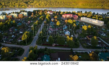 Russian village with wooden houses. Svir river and summer green forests of Leningrad region, Russia. Flying over roofs an urban-type settlement Nikolskiy. 