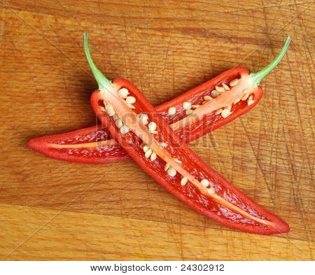 Rote Pfefferschote Scheiben Länge-Möglichkeiten auf Holz Schneidebrett. Shallow DoF, Schwerpunkt obere Chili-se