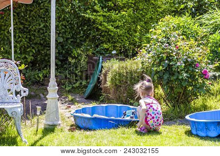 Adorable Little Girl Playing In A Sandbox.
