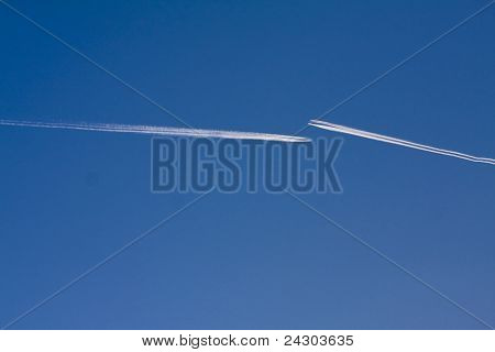 Jetplan med ånga ränder mot en blå himmel