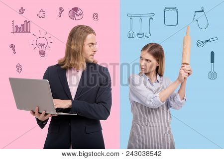 Real Threat. Angry Housewife Threatening Her Husband With A Rolling Pin While Getting Tired Of Doing