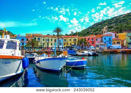 Giglio Island (grosseto), Italy, 05.20.2018: View Of The Little Port With Its Red Light House.