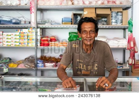BANDA NEIRA, MALUKU ISLANDS, INDONESIA, DECEMBER 19, 2017 : Portrait of a cheerful local convenient store seller in Banda Neira, Maluku islands, Indonesia.