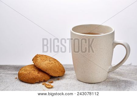 White Porcelain Mug Of Black Tea Or Earl Grey And Pile Of Sweet Cookies On Homespun Napkin Over Whit