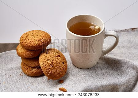 White Porcelain Mug Of Black Tea Or Earl Grey And Pile Of Sweet Cookies On Homespun Napkin Over Whit