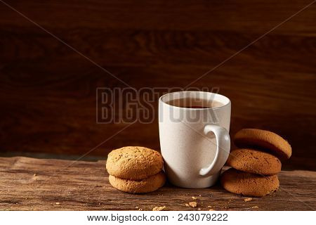 White Porcelain Mug Of Black Tea Or Earl Grey And Pile Of Sweet Cookies On Flat Piece Of Wood Over R
