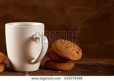 White Porcelain Mug Of Black Tea Or Earl Grey And Pile Of Sweet Cookies On Flat Piece Of Wood Over R