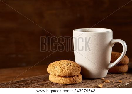 White Porcelain Mug Of Black Tea Or Earl Grey And Pile Of Sweet Cookies On Flat Piece Of Wood Over R
