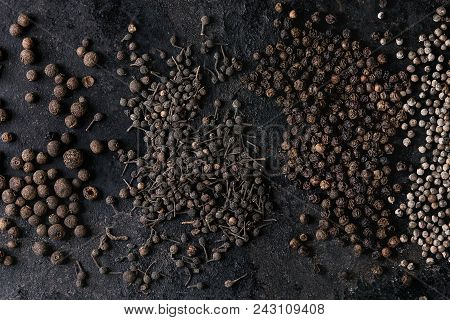 Variety Of Different Black Peppers Allspice, Pimento, Monks Pepper, Peppercorns Over Old Black Iron 