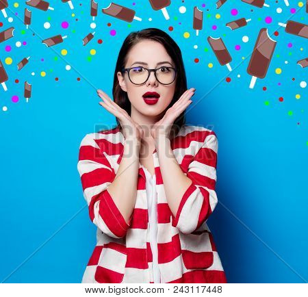 Portrait Of The Beautiful Young Surprised Woman On The Blue Background With Chocolade Ice-cream
