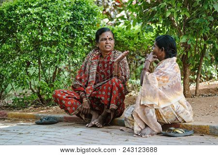 Two Indian Woman Sit On The Ground And Speaking. 8 February 2018 Sai Baba Ashram Puttaparthi