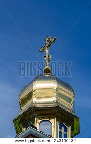 Wooden Orthodox Church With Gilded Domes On A Background Of Green Foliage Of Trees And A Bright Blue