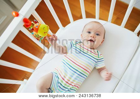 Baby Girl Lying In Co-sleeper Attached To Parents' Bed
