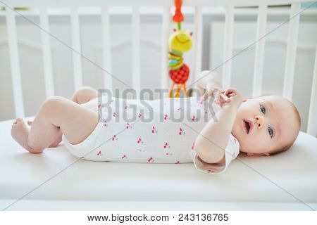 Baby Girl Lying In Co-sleeper Attached To Parents' Bed