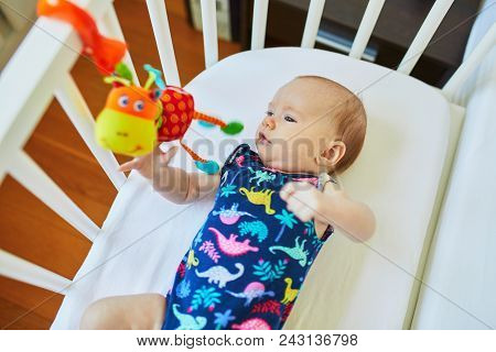 Baby Girl Lying In Co-sleeper Attached To Parents' Bed