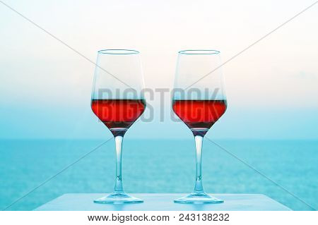 Two Glasses Of Red Wine On A Background Of Sea Horizon Morning. Two Glasses Of Red Wine With Blue Se
